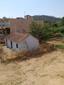 a small white house with a brown roof at PANAGIOTIS in Pefki