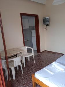 a room with a table and chairs and a kitchen at PANAGIOTIS in Pefki