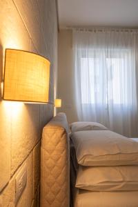 a bedroom with a bed and a lamp next to a window at Oronti Accommodations in Lecce
