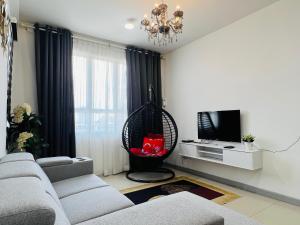 a living room with a couch and a hanging chair at VTH Homestay Drawbridge Ladang Tanjung, Kuala Terengganu with POOL, Drawbridge, KTCC Mall, Pasar Payang in Kuala Terengganu