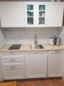 uma cozinha com armários brancos e um lavatório em Brunarica 6A - Smučišče Trije Kralji em Oplotnica