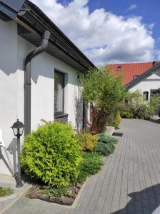 a house with a gambrel roof and a brick driveway at Domki pod Katalpami in Mikołajki