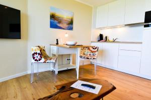 uma sala de estar com uma mesa e uma cozinha em Haus Horizont H511 em Cuxhaven
