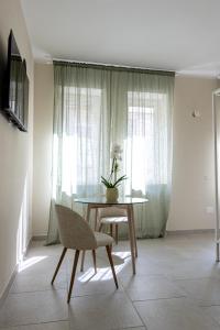 ein Tisch und Stühle in einem Zimmer mit Fenster in der Unterkunft Oronti Accommodations in Lecce