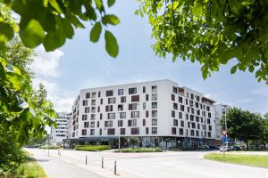 a white building on a city street with trees at Bonsai in Zagreb