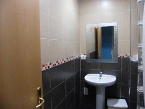La salle de bains est pourvue d'un lavabo et d'un miroir. dans l'établissement Pensión Corona, à Saragosse