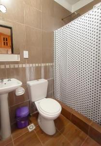 a bathroom with a white toilet and a sink at Bungalows La Pilarica in Federación +13 photos