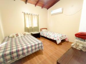 a bedroom with two beds and a window at Bungalows La Pilarica in Federación