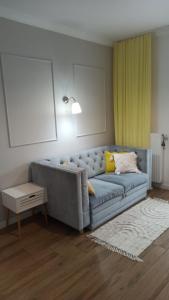 a living room with a blue couch and a table at Apartament na Starówce in Elblag