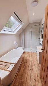duża łazienka z dużą wanną i prysznicem w obiekcie Nordlys Cottage w mieście Newton Stewart