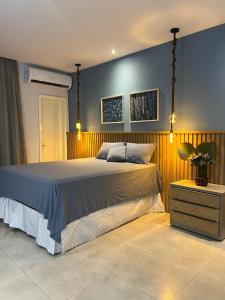 um quarto com uma cama grande e paredes azuis em Casa por temporada em Santarém