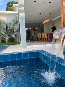 a swimming pool with a water fountain in a house at Casa por temporada in Santarém +14 photos
