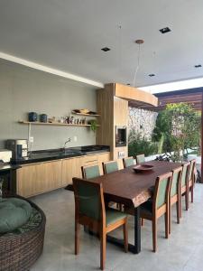 cocina y comedor con mesa de madera y sillas en Casa por temporada en Santarém