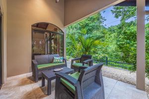 an outdoor patio with chairs and a table at Las Palomas Villas Of Uvita in Uvita