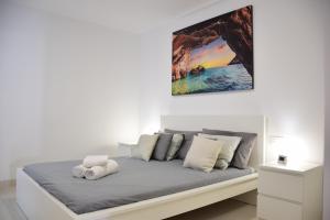 un letto in una camera bianca con un dipinto sul muro di Casa Brillante a Playa de San Juan