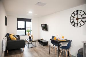 a living room with a couch and a clock on the wall at Luxurious City Center 1 BR Vibrant Liverpool in Liverpool