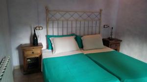 sypialnia z łóżkiem z zieloną i białą pościelą w obiekcie Can Pavet w mieście Pontons