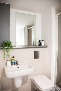 a white bathroom with a sink and a toilet at Luxurious City Center 1 BR Vibrant Liverpool in Liverpool