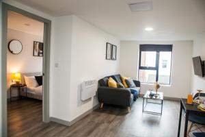 a living room with a couch and a table at Luxurious City Center 1 BR Vibrant Liverpool in Liverpool