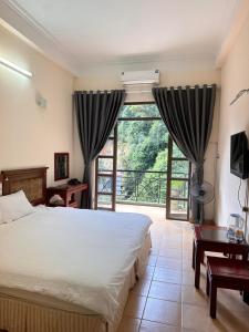 a bedroom with a bed and a large window at An Phú Motel Tam Đảo in Tam Ðảo