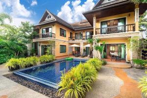 a house with a swimming pool in front of it at 6BR Laguna Bangtao Seaside Swimming Pool Villa in Phuket Town