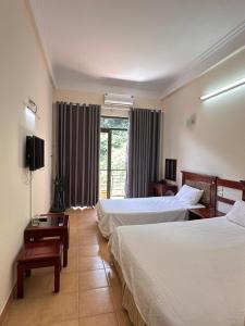 um quarto de hotel com duas camas e uma janela em An Phú Motel Tam Đảo em Tam Dao