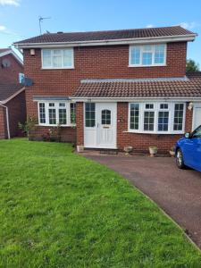 a brick house with a car parked in the driveway at 4 Bedroom House EMA with Parking and Garage in Castle Donington