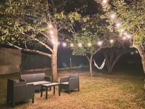 um jardim com duas cadeiras, um sofá e luzes em Casa con giardino in Mugello a 30 minuti da Firenze "SoleLuna" em Osteria di Novoli