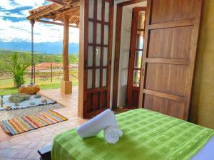 una camera con un letto verde e una porta aperta di Cabaña Villa Chelita descanso y confort. a Barichara