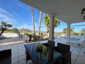 un patio con mesa, sillas y piscina en Villa Hermosa with a private pool, en Baños y Mendigo