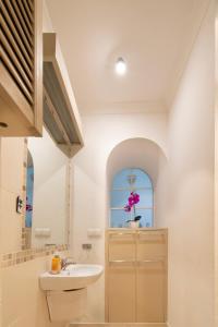 a white bathroom with a sink and a window at Stylish 2 bedroom apartment Morsztynowska street in Kraków
