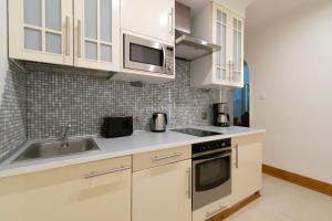 a kitchen with white cabinets and a sink at Stylish 2 bedroom apartment Morsztynowska street in Krakow