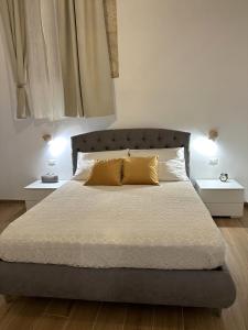 een slaapkamer met een groot bed met 2 nachtkastjes bij Appartamento Aretusa di G&G in Siracusa