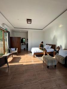 a man sitting on a bed in a bedroom at The luxe villas lombok in Kuta Lombok