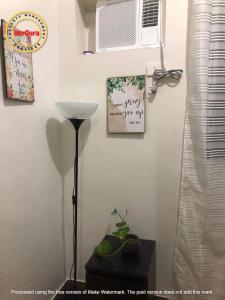 un angolo di una camera con una pianta e un ventilatore di Trees Residences 2 Bedroom Unit T21 by HerGura PMS a Manila