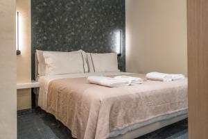 a bedroom with a bed with two towels on it at Piazza Luxury Apartments in Tirana