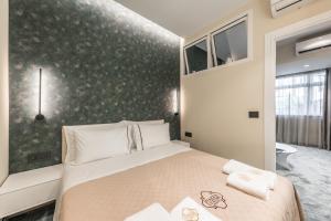 um quarto com uma cama e uma parede verde em Piazza Luxury Apartments em Tirana