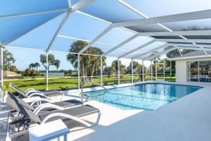 a swimming pool with chairs and an umbrella at Triple En-Suite Pool Retreat - All Master Bedrooms in Inverness
