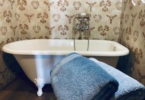 a bathroom with a white tub and a blue towel at La Casina di Venere in Savoca 