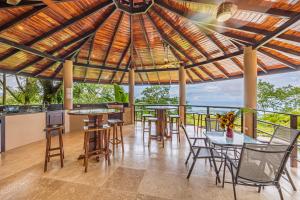 un restaurante con mesas y sillas y vistas al océano en Las Palomas Villas Of Uvita, en Uvita