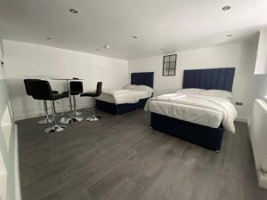 a bedroom with two beds and a table and chairs at ENTIRE MODERN HOUSE in Elland