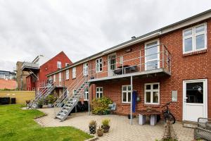 a brick building with a staircase on the side of it at Charmerende lejlighed in Fredericia