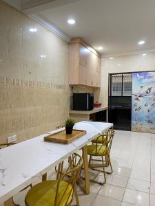- une cuisine avec une table et des chaises dans la chambre dans l'établissement Unique 4 Bedrooms House, Few mins to Town by Mr Homestay, à Teluk Intan