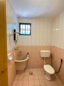 La salle de bains est pourvue de toilettes, d'une baignoire et d'un lavabo. dans l'établissement Unique 4 Bedrooms House, Few mins to Town by Mr Homestay, à Teluk Intan