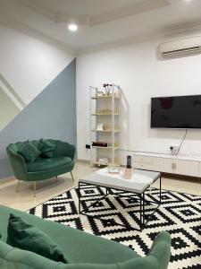 sala de estar con sofá y TV en Unique 4 Bedrooms House, Few mins to Town by Mr Homestay en Teluk Intan