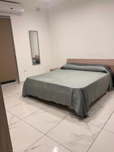 um quarto com uma cama e um espelho num piso de azulejo em 3 bedroom apartment in Marsascala em Marsaskala