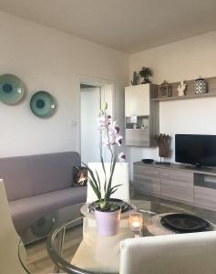 Una sala de estar con un sofá y una mesa de cristal. en FamilyBO Apartments Bologna Delight - front station, en Bolonia