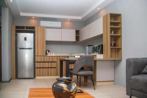 uma cozinha com uma mesa, uma cadeira e um frigorífico em LAVIDA em Abidjan