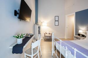 - une chambre avec un lit et une télévision murale dans l'établissement Maison Rêve Torino Centro, à Turin