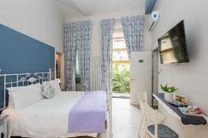 een slaapkamer met een bed, een tv en een raam bij Maison Rêve Torino Centro in Turijn